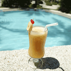 Image of glass full of a fruity drink on the edge of a pool