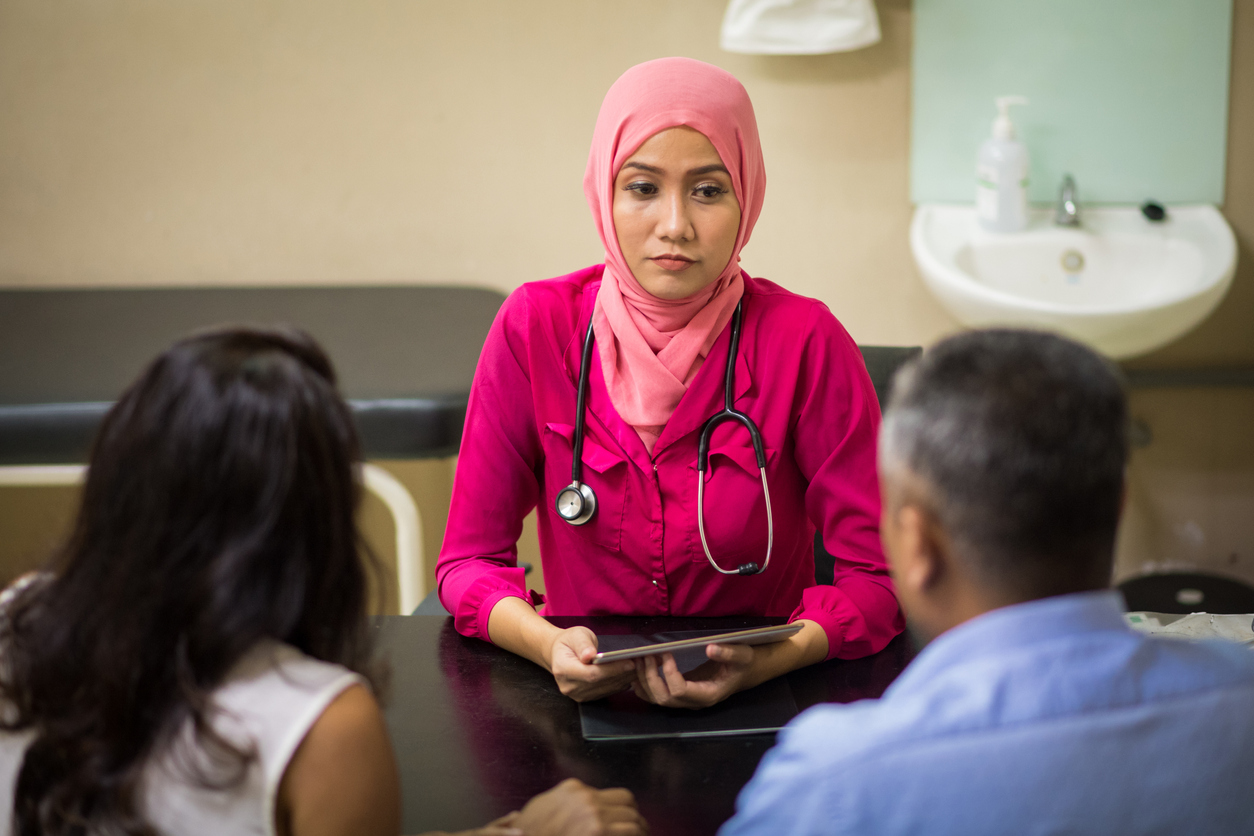 Female Muslim Doctor consulting with patients