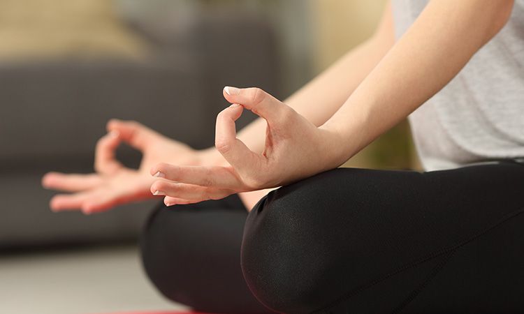 An image of a woman sitting in a yoga pose is used to illustrate the concept of New Year's resolutions, which often involve health and fitness practices such as yoga.