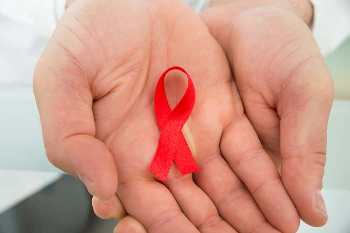 hand holding AIDS ribbon