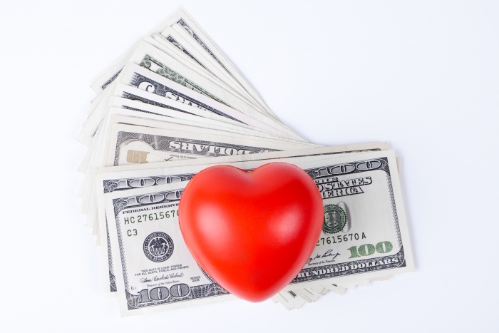 red heart on top of dollars white background