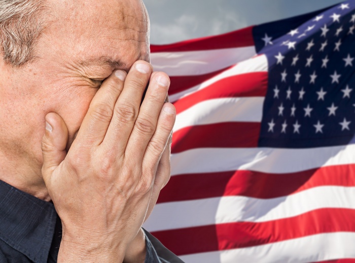 Veteran. Portrait of an elderly man with face closed by hand on USA flag background