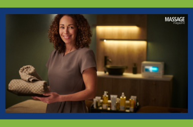 Image for an article about the stages of massage business growth. Image of massage therapist preparing a treatment room.