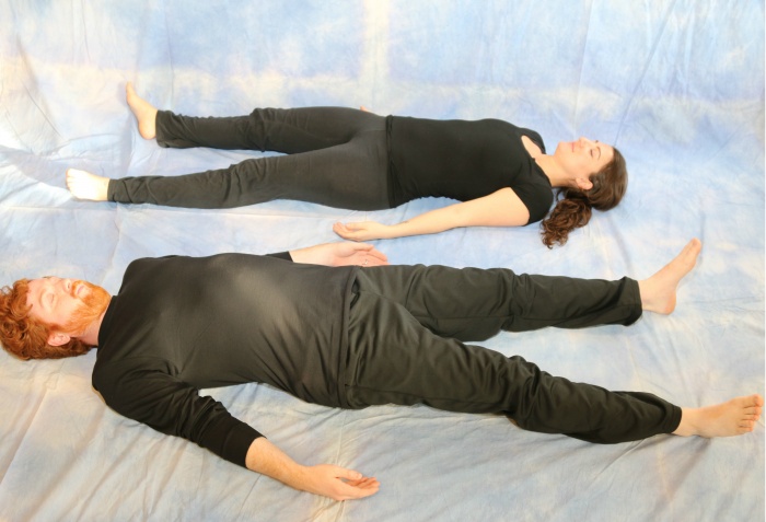 two yoga practitioners doing corpse pose