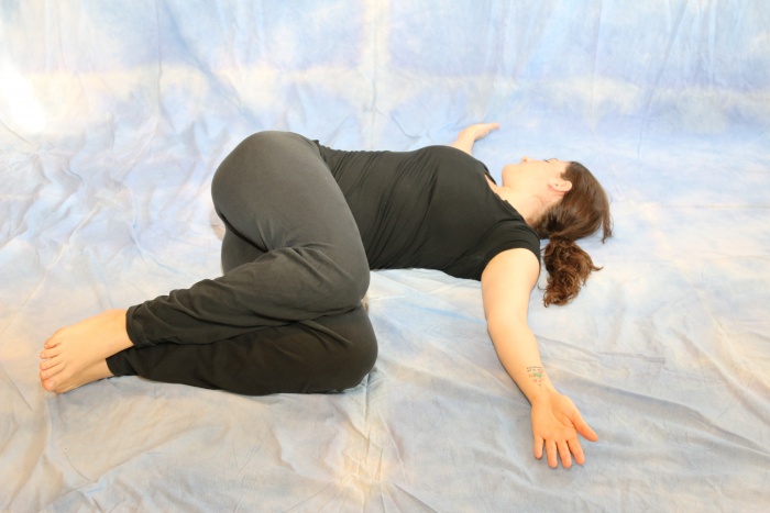 lone yoga practitioner doing knee down twist