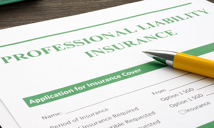 An image of a pen and an insurance form is used to illustrate the concept of protecting your practice with massage liability insurance.