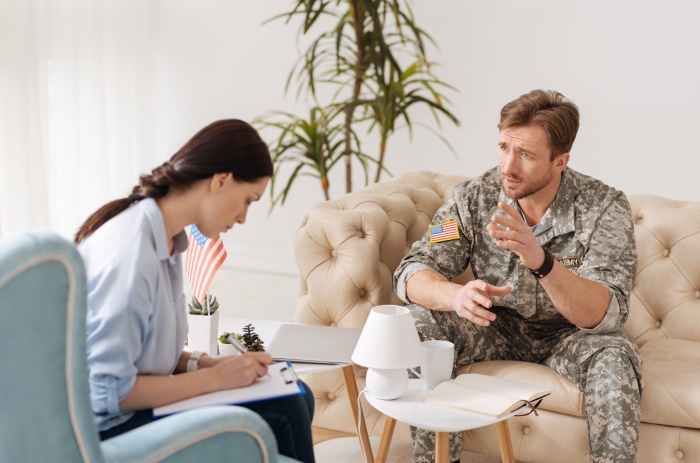 military man sitting on the sofa and talking to his therapist while discussing his problems