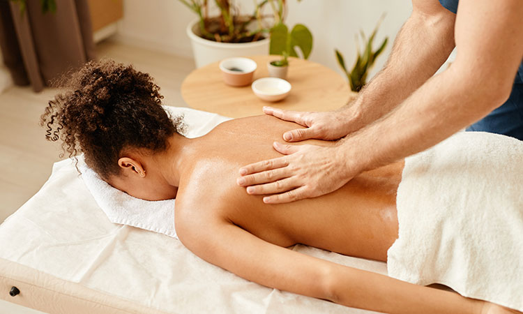 An image of a client getting a massage from a massage therapist is used to illustrate the concept of mindful massage.