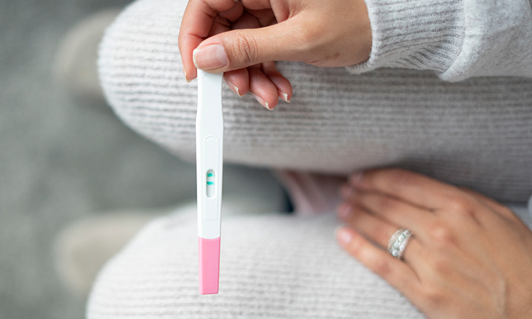 A photo of a positive pregnancy test is used to illustrate the concept of pregnancy, and the myth that massage is contraindicated during much of pregnancy.