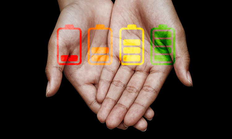 An image of hands with battery indicators superimposed over them is used to illustrate the concept of burnout and overwhelm.