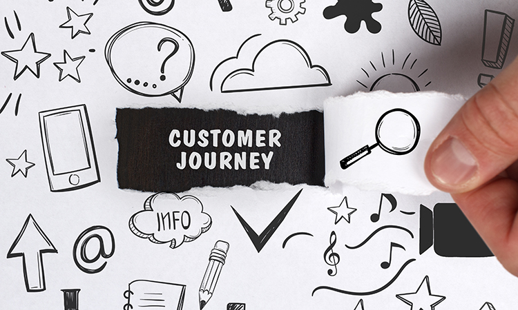 A thumb a finger peel away paper to reveal the words "Customer Journey"