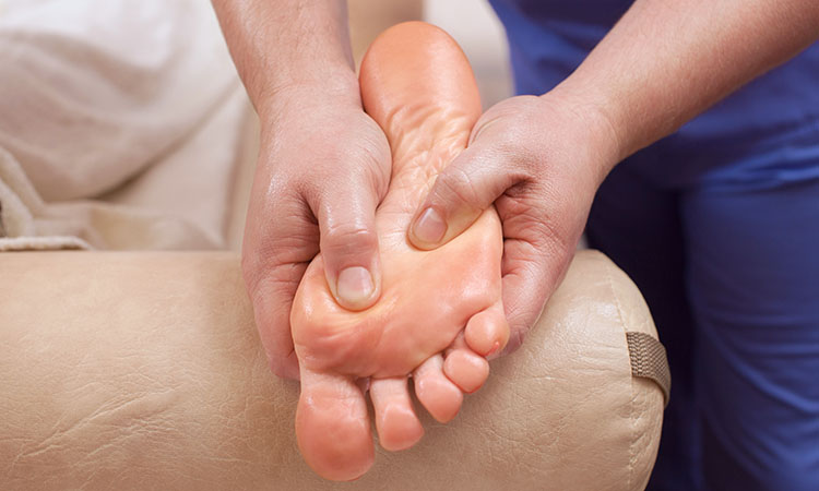 A therapist Treating plantar fasciitis with massage therapy on a client
