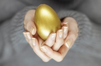 hands holding golden egg -- concept of financial success