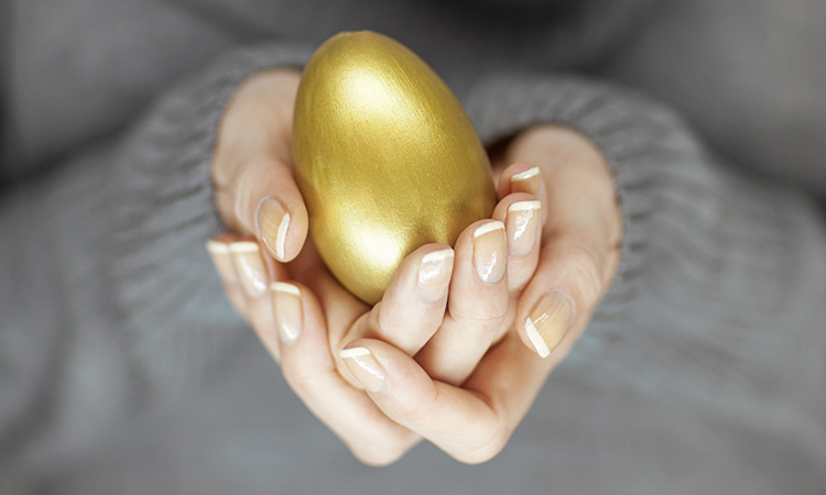 hands holding golden egg - financial success concept