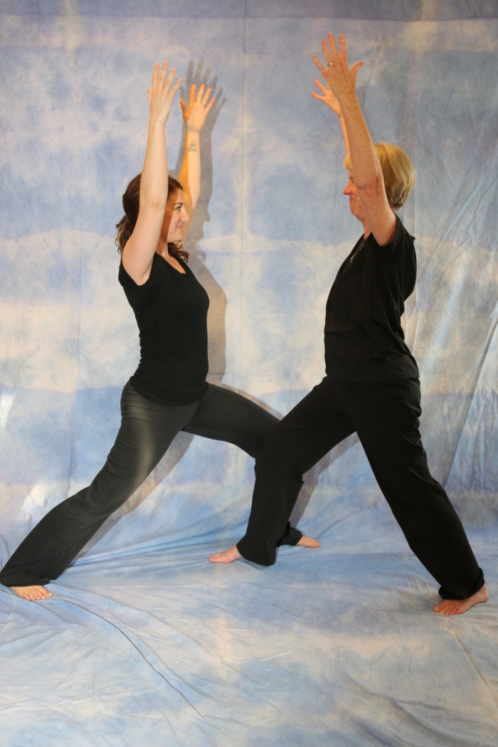 Two yoga practitioners doing Warrior pose