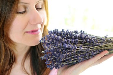 woman smelling lavender to use aromatherapy