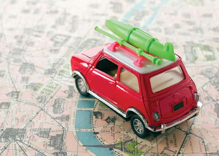 Car with kayak on roof rack on map