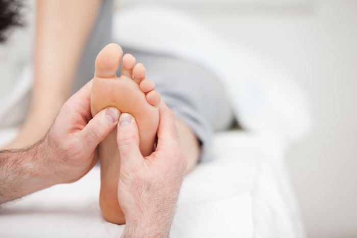 Foot being massaged on a medical table in a room