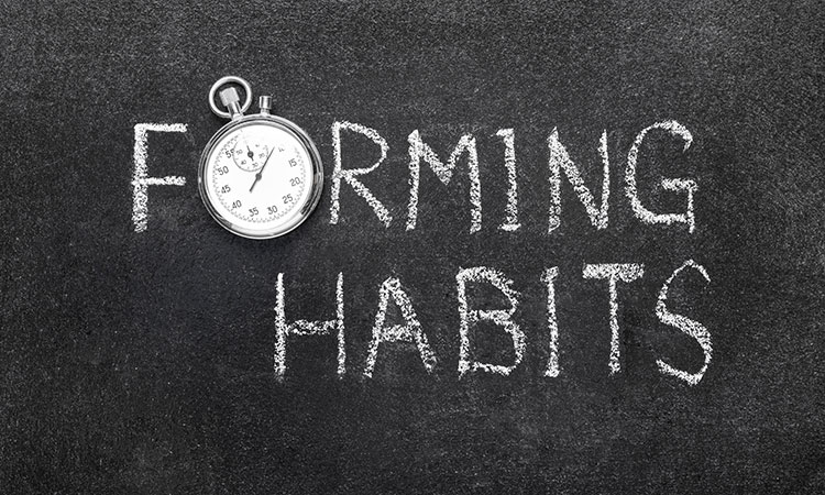 An image of a black chalkboard, with the words "forming habits" printed on it with white chalk, is used to illustrate the concept of forming behavioral habits.
