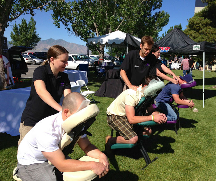 Massage therapists provide chair massage at a company party.