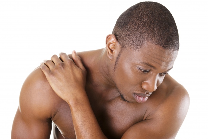 Young man with back pain, isolated on white