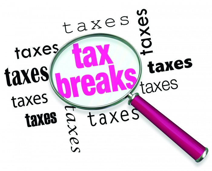 A magnifying glass hovering over the word tax breaks, symbolizing the advice and tricks that an accountant can use to increase deductions and save money when filing tax returns